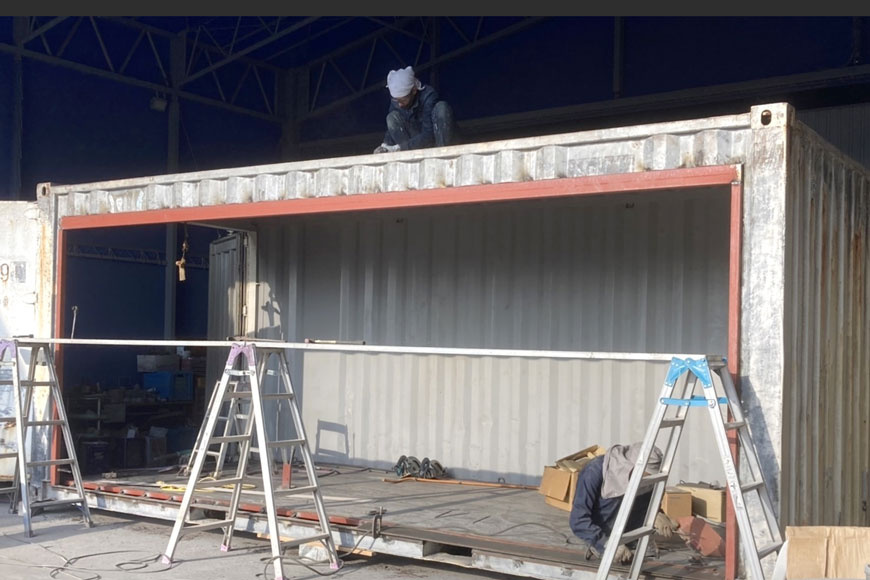 コンテナの側面を加工している作業風景